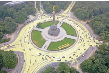  ?? FOTO: DPA ?? Aktivisten trugen am Dienstag rund um die Siegessäul­e in Berlin ökologisch abbaubare Farbe auf. Mit dem Protest unter dem Motto „Sonne statt Kohle“kämpft Greenpeace für den Kohleausst­ieg.