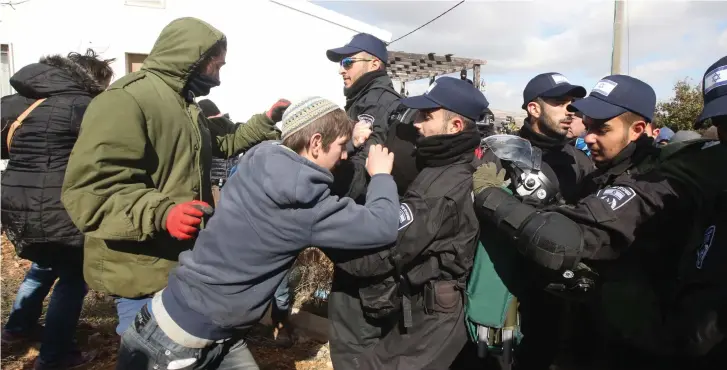  ?? (Marc Israel Sellem/The Jerusalem Post) ?? RIGHT-WING ACTIVISTS scuffle with security forces during the evacuation of the Amona outpost yesterday.