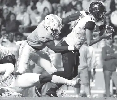  ?? STAFF FILE PHOTO BY ERIN O. SMITH ?? Tennessee’s Jonathan Kongbo grabs Vanderbilt quarterbac­k Kyle Shurmur as he runs the ball during the game last November at Neyland Stadium in Knoxvillen. Vanderbilt beat Tennessee 42-24. Kongbo is moving from defensive end to outside linebacker for the...