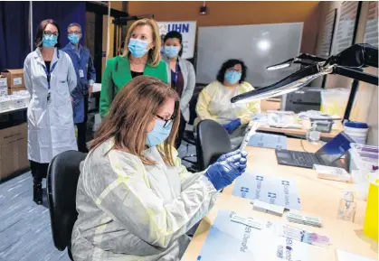  ?? REUTERS ?? Pharmacy technician supervisor Tamara Booth Rumsey prepares a Pfizer-BioNTech vaccine at The Michener Institute in Toronto on Monday.