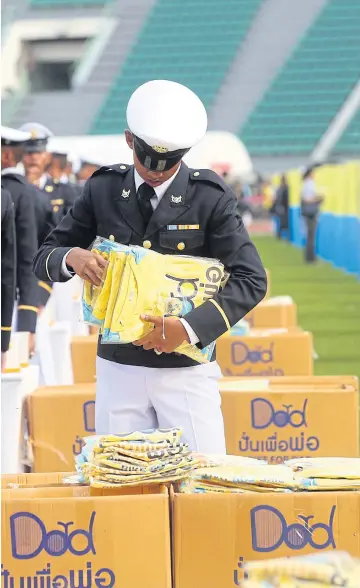  ??  ?? BESPOKE FASHION: A military cadet prepares T-shirts for distributi­on to cyclists who have registered for next week’s ‘Bike for Dad’ event.