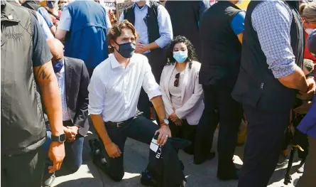  ??  ?? Canadian Prime Minister Justin Trudeau takes a knee as he takes part in an anti-racism protest on Parliament Hill during the Covid-19 pandemic in Ottawa on Friday. The death of George Floyd, a black man, after a Minneapoli­s white police officer knelt on his neck on May 25, has ignited protests in the US and worldwide over racial injustice and police brutality. — AP/PTI