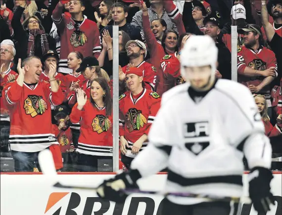  ?? NAM Y. HUH ASSOCIATED PRESS ?? Blackhawks fans cheer and the Kings’ Slava Voynov looks away after Duncan Keith’s tiebreakin­g goal in the second period.