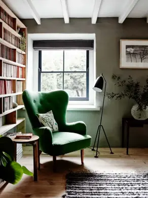  ??  ?? LIVING ROOM In a cosy corner, a vintage Ernest Race DA1 armchair is a perfect spot for curling up with a good book. Upholstere­d in a vibrant green, it’s a stylish highlight against soft green walls. The artwork on the wall is by Jenny Morse
DINING ROOM The ground floor of the farmhouse has a modern layout with the kitchen open to the dining area, where a large table made from leftover Dinesen Douglas Fir flooring timber is surrounded by Arne Jacobsen Grand Prix chairs