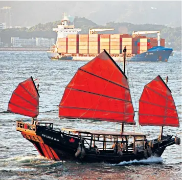  ??  ?? A traditiona­l Chinese junk and a modern container ship in Hong Kong: the former colony has shown the world the power of free trade