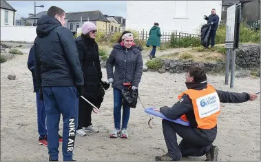  ??  ?? Alan Watson signs up people for the beach clean up