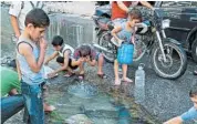  ?? RAJA ABDULRAHIM/TRIBUNE NEWSPAPERS ?? Children play in a pool of water in Aleppo, Syria. Syrians talk about a “lost generation” of their children.