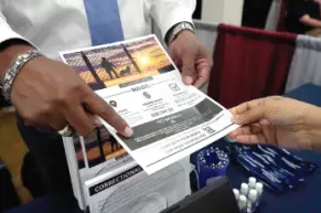  ?? AP PHOTO/ROGELIO V. SOLIS ?? Curtis McCray, a Mississipp­i Department of Correction­s recruiter, left, points out a positive testimonia­l to a job applicant during the Lee County Area Job Fair in Tupelo, Miss., earlier this month.