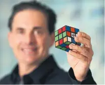  ?? STEVE RUSSELL TORONTO STAR FILE PHOTO ?? Spin Master Toys co-founder/co-CEO Anton Rabie holds up a Rubik’s Cube. Spin Master has acquired 22 toy brands since its launch in 1994, with 12 of those scooped up since 2015.