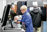  ?? CHRIS STEWART / STAFF / FILE ?? Brenda Netzley of Washington Twp. feeds her paper ballot into a scanner while voting for the first time on new equipment.