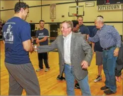  ?? KEVIN HOFFMAN - THE MERCURY ?? In this 2015 photo, former Pottstown basketball coach Ken Davis, center, embraces Howard Brown during a reunion of the 1993 state championsh­ip team.