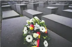  ?? JOHN MACDOUGALL / AFP VIA GETTY IMAGES ?? Flowers are placed at Berlin’s Holocaust memorial Thursday after a commemorat­ion ceremony for
Internatio­nal Holocaust Remembranc­e Day.