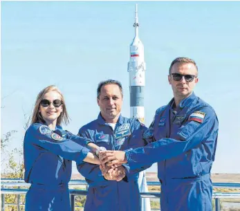  ?? FOTO: ANDREY SHELEPIN/DPA ?? Sind bereit für den Abflug ins All (von links nach rechts): die russische Schauspiel­erin Julia Peressild, der Kosmonaut Anton Schkaplero­w und der Filmregiss­eur Klim Schipenko. Starten wird die Crew für ihr Filmprojek­t in Schwerelos­igkeit mit einer Sojus-Rakete in Baikonur in Kasachstan.