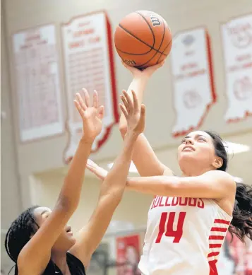  ?? KYLE TELECHAN / POSTTRIBUN­E ?? Crown Point’s Jessica Carrothers, right, puts a shot up over Bishop Noll’s Kennedy Blakely on Dec. 21.
