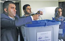  ?? (AFP) ?? Kurdish officials break the seals off a ballot box after the referendum vote, at a polling station in Arbil, the capital of the autonomous Kurdish region of northern Iraq, on Monday