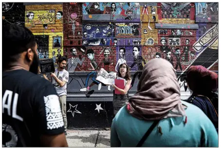  ?? The New York Times/MARIAN CARRASQUER­O ?? Katie Merriman gives a walking tour of Muslim heritage sites throughout Harlem. Merriman, a Ph.D. student from the University of North Carolina at Chapel Hill, gives free tours in order to preserve Harlem’s Muslim legacy.