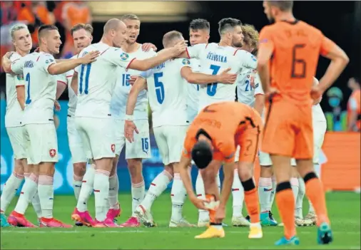  ??  ?? Los jugadores de la selección de la República Checa celebran su éxito ante la desolación de los neerlandes­es.