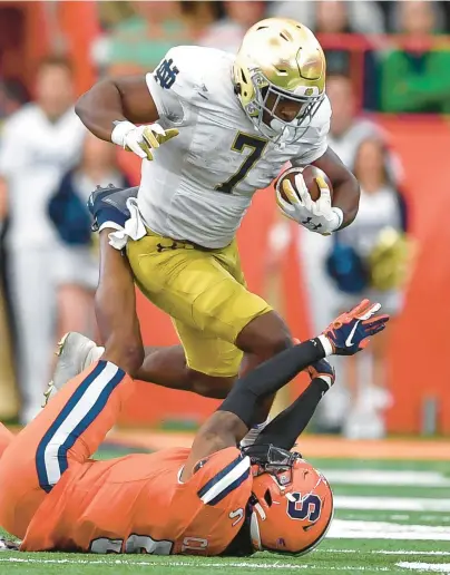  ?? ADRIAN KRAUS/AP ?? Notre Dame running back Audric Estime (7) runs over Syracuse linebacker Alijah Clark (5) during a game Oct. 29. Estime leads the Fighting Irish with nine rushing touchdowns this season.