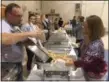  ?? KEVIN MARTIN — THE MORNING JOURNAL ?? Volunteers serve up Thanksgivi­ng dinner on Nov. 23 at the Parish Hall of St. Mary’s Roman Catholic Church at 320 Middle Ave. in Elyria.