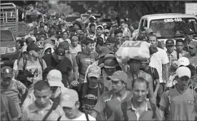  ?? MOISES CASTILLO AP PHOTO ?? Honduran migrants walk toward the U.S. as they arrive at Chiquimula, Guatemala, on Tuesday. U.S. President Donald Trump threatened on Tuesday to cut aid to Honduras if it doesn’t stop the impromptu caravan of migrants, but it remains unclear if government­s in the region can summon the political will to physically halt the determined bordercros­sers.