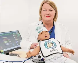  ?? Sam Owens/staff photograph­er ?? Donna Wallis, director of nursing at Palo Alto College, shows off a new toddler-size medical mannequin that will be used by nursing program students at the new Southside Education and Training Center.