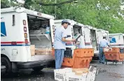  ?? [J. SCOTT APPLEWHITE/ASSOCIATED PRESS FILE PHOTO] ?? In this July 31 photo, letter carriers load mail trucks for deliveries at a U.S. Postal Service facility in McLean, Va.