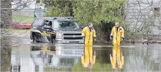  ??  ?? Firefighte­rs check on residents in a part of Rothesay, N.B., that was cut off by floodwater­s on Friday.