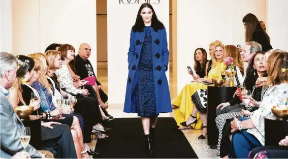  ?? Photos by Marie D. De Jesús / Staff photograph­er ?? Andrew Gn featured a wool coat with textured collar over an animal-print dress on the catwalk at Tootsies during his recent visit to Houston.