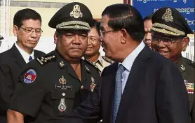 ??  ?? Under scrutiny: Hun Sen (right) has ruled Cambodia for 33 years with Bun Hieng (second from left) heading his bodyguard unit. — AP