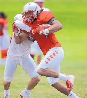  ?? ADOLPHE PIERRE-LOUIS/JOURNAL ?? UNM running back Micah Gray, right, tries to break a tackle attempt from safety Johnny Hernandez during Friday’s practice.