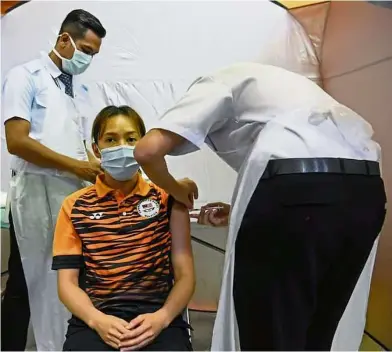  ??  ?? Protect oneself, protect all: Tokyo Olympics-bound diver Leong Mun Yee getting her first Covid-19 vaccine shot on Tuesday.