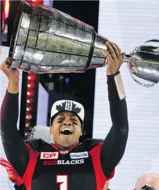  ?? MICHAEL PEAKE ?? Henry Burris hoists the Grey Cup last November after Ottawa’s win over Calgary. The retired pivot will take the trophy to London’s Trafalgar Square on Canada Day as part of 150th-birthday celebratio­ns.