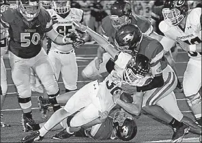  ?? Special to the NWA Democrat-Gazette/MARK STALLINGS ?? Kenny Wood of Greenwood (middle) fights off two Alma defenders Friday to score a touchdown during the Bulldogs’ 54-28 victory over the Airedales in Alma. For more high school football photos, visit arkansason­line.com/galleries.