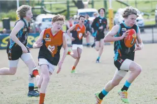  ??  ?? Cora Lynn player Liam Taylor breaks away from Koo wee rup opponent Luke Glassbarro­w