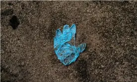  ?? Photograph: Guillermo Arias/AFP via Getty Images ?? View of a surgical glove on the ground near new common graves in Tijuana, Mexico – now the murder capital of the world.