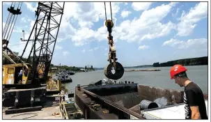  ?? AP/DARKO VOJINOVIC ?? A worker directs a crane lifting a roll of coiled steel plate onto a barge in Smederevo, east of Belgrade, Serbia, on June 29. Hebei Iron & Steel’s $52 million purchase of the Steelworks Smederevo is part of China’s effort to project influence and gain...