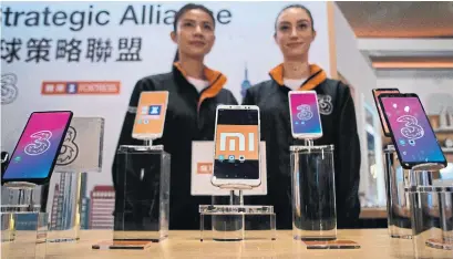  ?? ANTHONY WALLACE/AFP/GETTY IMAGES ?? Chinese smartphone maker Xiaomi chose Hong Kong for its IPO after regulation­s were changed to discourage going abroad.