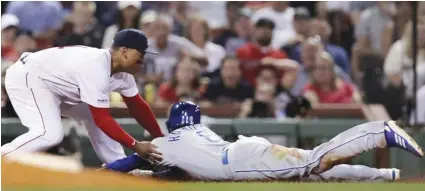  ??  ?? Boston Red Sox third baseman Rafael Devers (left) tags out Kansas City Royals’ Billy Hamilton (right) who tried to advance to third on a flyout during the fourth inning of a baseball game at Fenway Park in Boston, on Aug. 7. AP PHOTO/CHARLES KRUPA