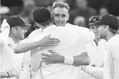  ??  ?? England bowler Stuart Broad (C) celebrates with teammates after taking the wicket of West Indies’ captain Jason Holder during play on day 3 of the first Test cricket match between England and the West Indies at Edgbaston in Birmingham, central England...