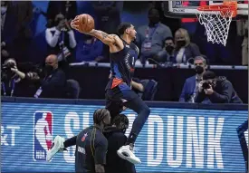  ??  ?? The Knicks’ Obi Toppin showed creativity, jumping over his father, Obadiah Toppin, and teammate Julius Randle on a dunk which earned 46 points Sunday.