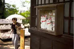  ??  ?? Photo shows a woman looking at cat figurines called ‘maneki-neko’.