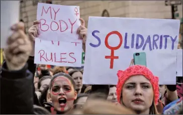  ?? The Associated Press ?? DEMONSTRAT­ION: Participan­ts carry signs and chant during an Internatio­nal Women's Day rally in the shadow of New York's Trump Tower on Wednesday in New York.