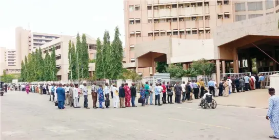  ?? PHOTO: NAN ?? Civil Servants queuing to be screened by security operatives at the entrance of the Federal Secretaria­t in Abuja, yesterday.