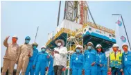  ?? Photo: AP ?? President Yoweri Museveni (centre) and workers from China mark the start of drilling at the Kingfisher oilfield on Lake Albert.