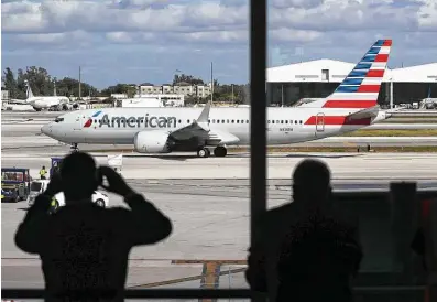  ?? Joe Raedle / Getty Images ?? American Airlines Flight 718 pulls away from its gate at Miami Internatio­nal Airport on its way to New York City on Tuesday. The Boeing 737 Max flew its first commercial flight nearly two years after being grounded worldwide.