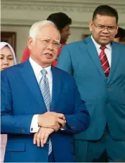  ??  ?? Ready for trial: Najib with Umno Supreme Council member Datuk Lokman Noor Adam leaving the courthouse.