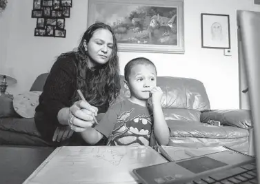  ?? PAUL KITAGAKI JR./SACRAMENTO BEE ?? Rosario Correa, 34, and her son Michael Gamino Correa, 5, participat­e in his school Zoom class at home March 18 in Sacramento. The Latina mother changed her work schedule to help supervise her children’s schooling.