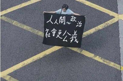  ?? Picture: AFP ?? ACTION. A man holds a banner as he joins others during a pro-democracy flash mob rally at lunchtime in the Central district in Hong Kong yesterday. The semi-autonomous Chinese city has been upended by nearly five months of huge, often violent, pro-democracy demonstrat­ions as Beijing and city leaders adopt a hardline approach.