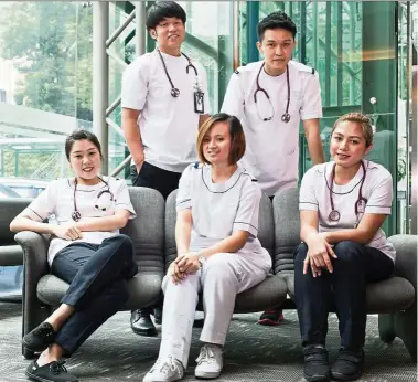  ??  ?? UCSI’s Bachelor of Nursing students Daniel Chan (standing, right) and Rooney Saw (standing, left) are determined to join their female counterpar­ts in the nursing field and do their part in the noble service.