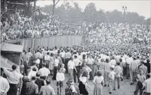  ?? WATERLOO REGION RECORD HISTORICAL COLLECTION ?? Several police officers escort Gordon Bradshaw to the umpires’ dressing room while irate Panthers’ fans of all ages create a near-riot.